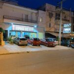 Εξωτερική όψη του Fotopoulos Fotis Auto Service στην Ηλιούπολη τη νύχτα.