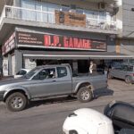 Πινακίδα με το λογότυπο του συνεργείου D.P GARAGE