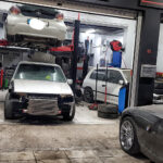 Αυτοκίνητα στο χώρο του συνεργείου APRO Racing, κάποια σε ανυψωτικό.