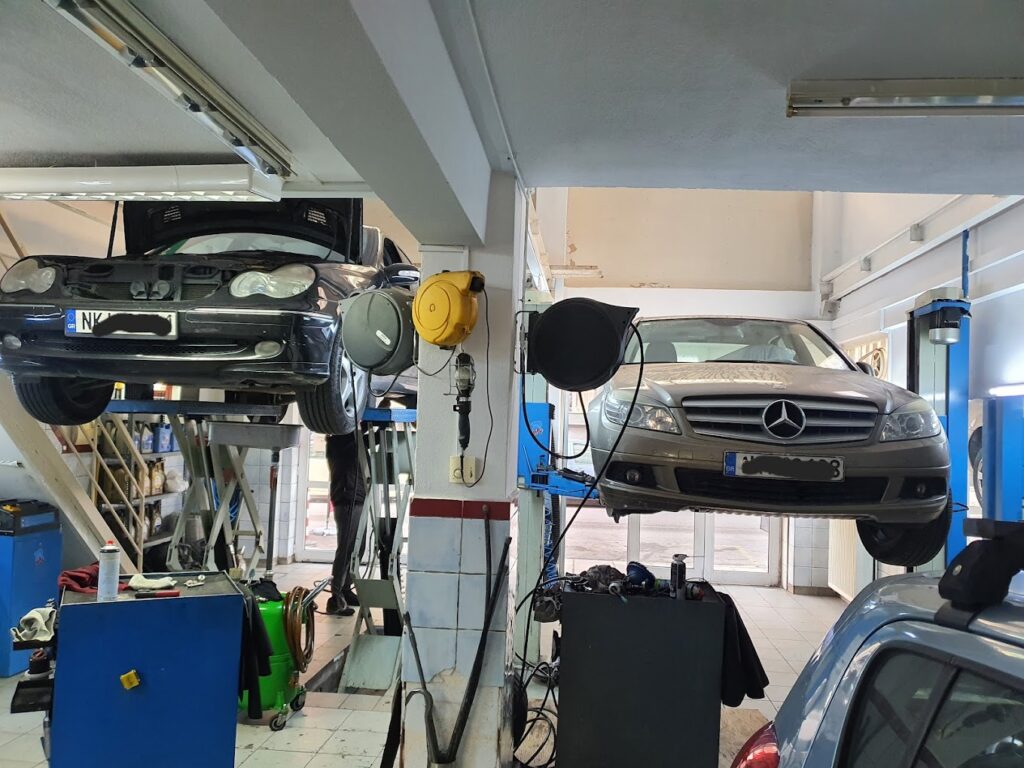 Τεχνικός αυτοκινήτων στο συνεργείο "Ο Άγιος" εργάζεται πάνω σε μηχανή αυτοκινήτου.
