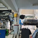 Τεχνικός αυτοκινήτων στο συνεργείο "Ο Άγιος" εργάζεται πάνω σε μηχανή αυτοκινήτου.