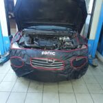 Αυτοκίνητο έτοιμο για service στο συνεργείο "Ο Άγιος", με ανοιχτό καπό.