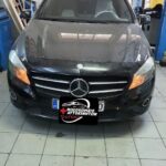 Αυτοκίνητο Mercedes στο συνεργείο "Ο Άγιος" πριν από επισκευή, με ανοιχτό καπό.