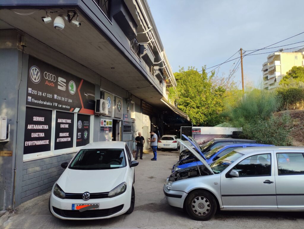 Δύο αυτοκίνητα έξω από το Theodorakakis Service για συντήρηση.