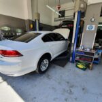 Λευκό αυτοκίνητο σε ανυψωτήρα για service στο D & P AUTO WORKSHOP Ηλιούπολη.