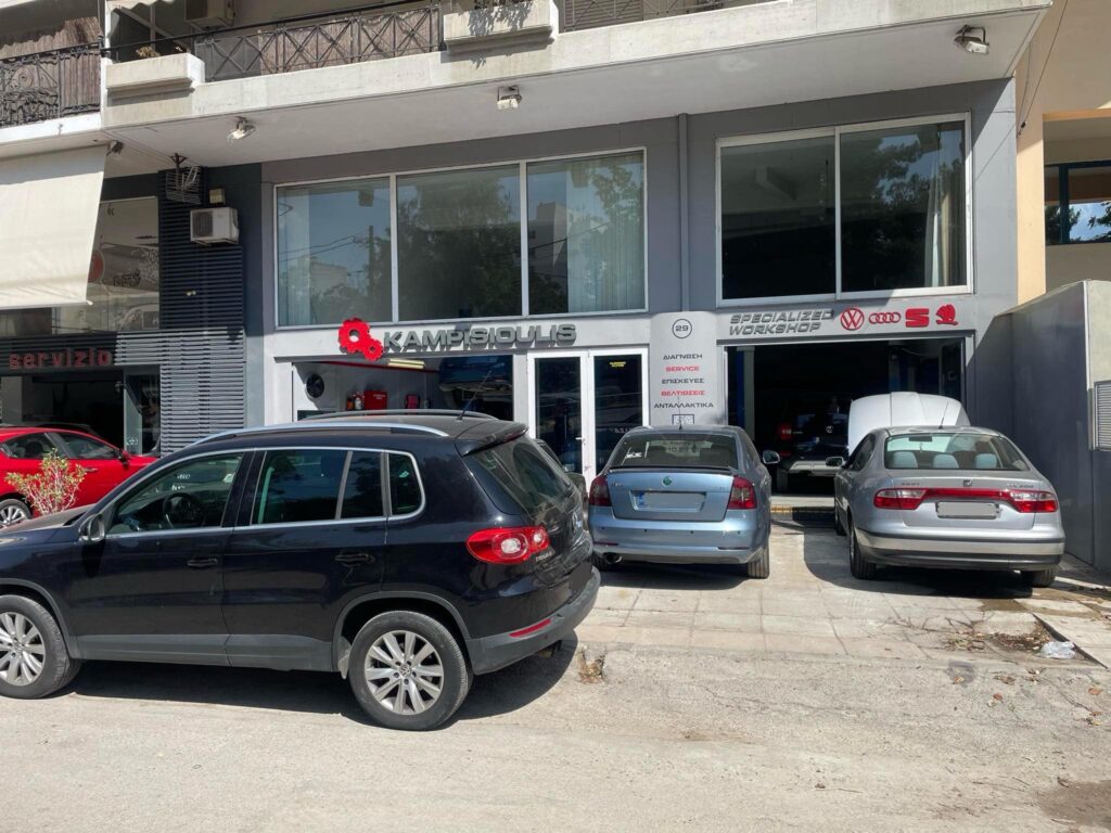 Εξωτερικός χώρος του KAMPISIOULIS Workshop με παρκαρισμένα Seat, Skoda, VW και Audi.