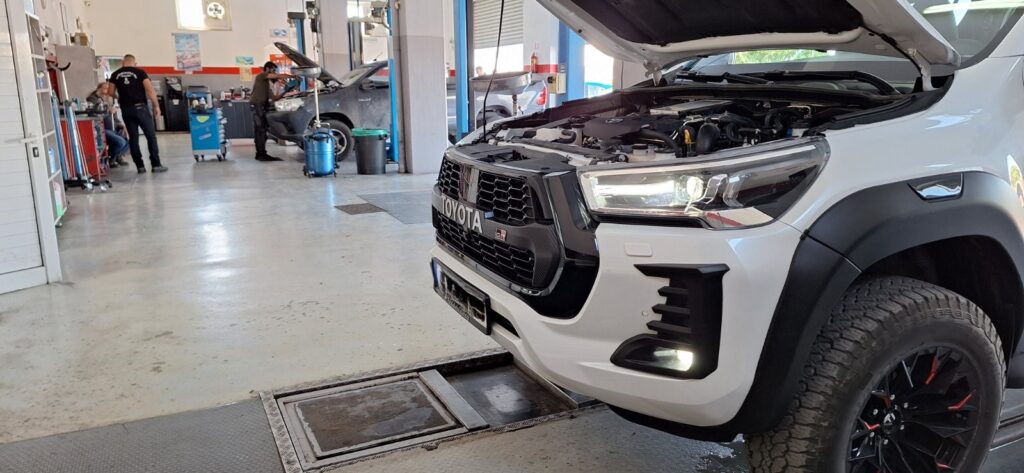 Toyota Hilux με ανοιχτό καπό για έλεγχο κινητήρα στο συνεργείο Rigakis Auto Service.