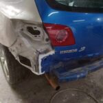 Μπλε αυτοκίνητο με εκτεταμένη ζημιά στον πίσω προφυλακτήρα και φτερό.