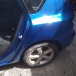 Κοντινή εικόνα πλαϊνού μέρους μπλε αυτοκινήτου μετά από βαφή και επιδιόρθωση.