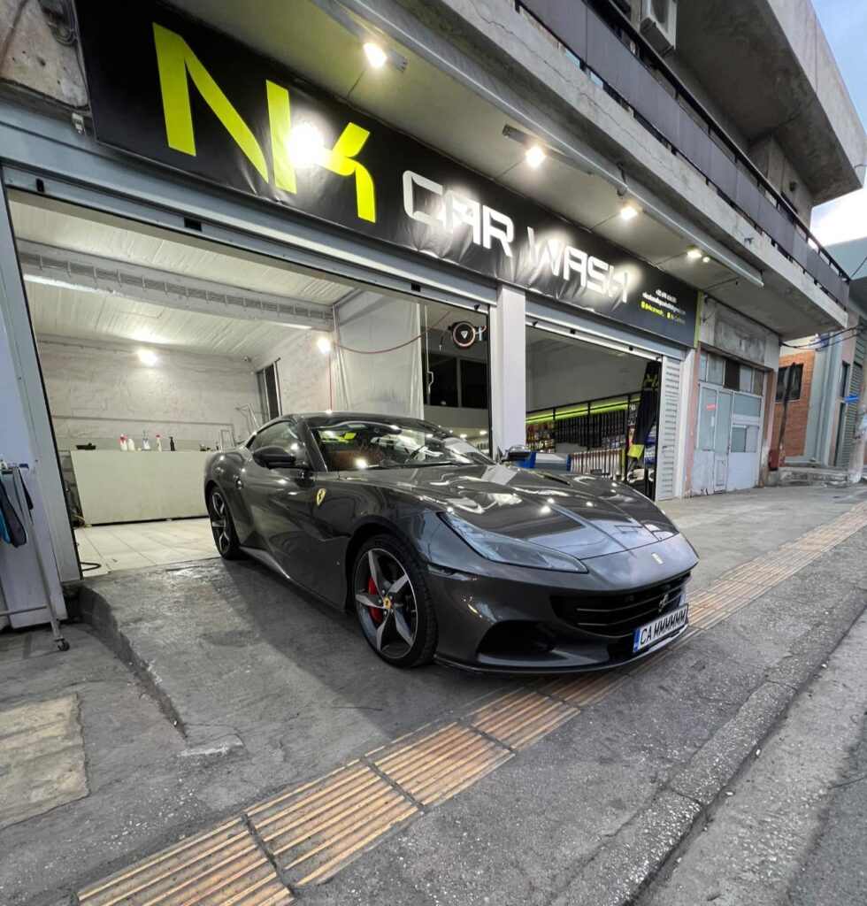 Είσοδος του NK Car Wash στο Πέραμα με πολυτελές αυτοκίνητο έτοιμο για καθαρισμό.